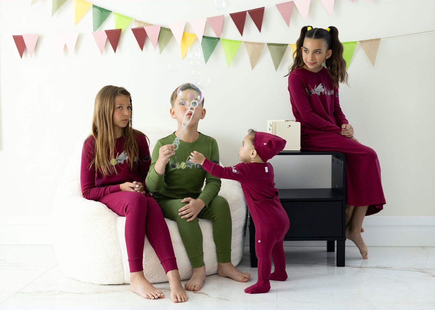 Kids in matching Dottie Lou sleepwear with music print in berry and moss green — family photo