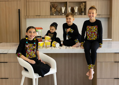 Kids in matching Dottie Lou Brush Pop black pajamas with colorful doodle print — family photo 14