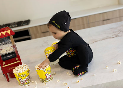Child in Dottie Lou Brush Pop black pajamas with colorful doodle print — solo child model photo 3
