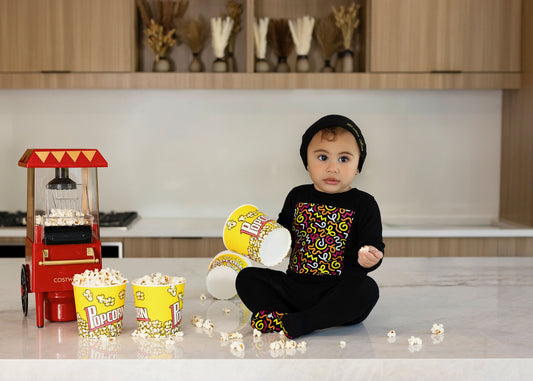 Child in Dottie Lou Brush Pop black pajamas with colorful doodle print — solo child model photo 4