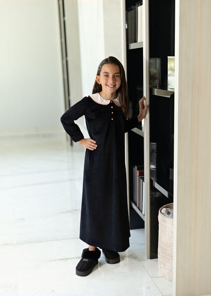 Child wearing Dottie Lou Classic Noir black velour loungewear with ivory Peter Pan collar and orange piping — solo child model photo 7