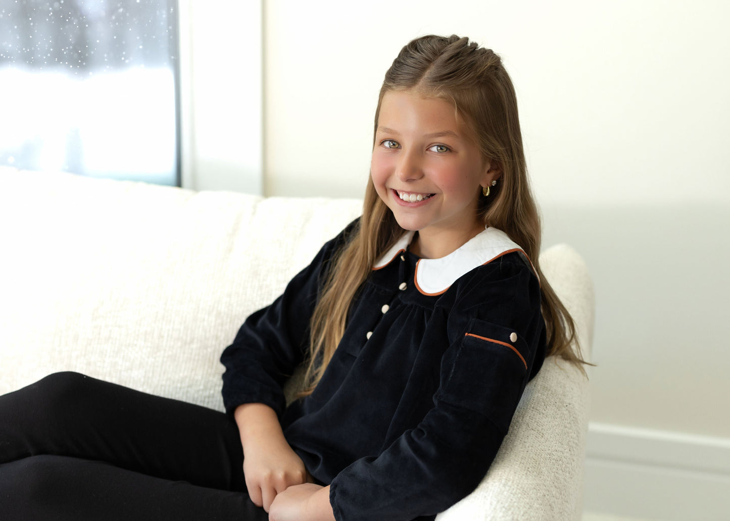 Child wearing Dottie Lou Classic Noir black velour loungewear with ivory Peter Pan collar and orange piping — solo child model photo 12