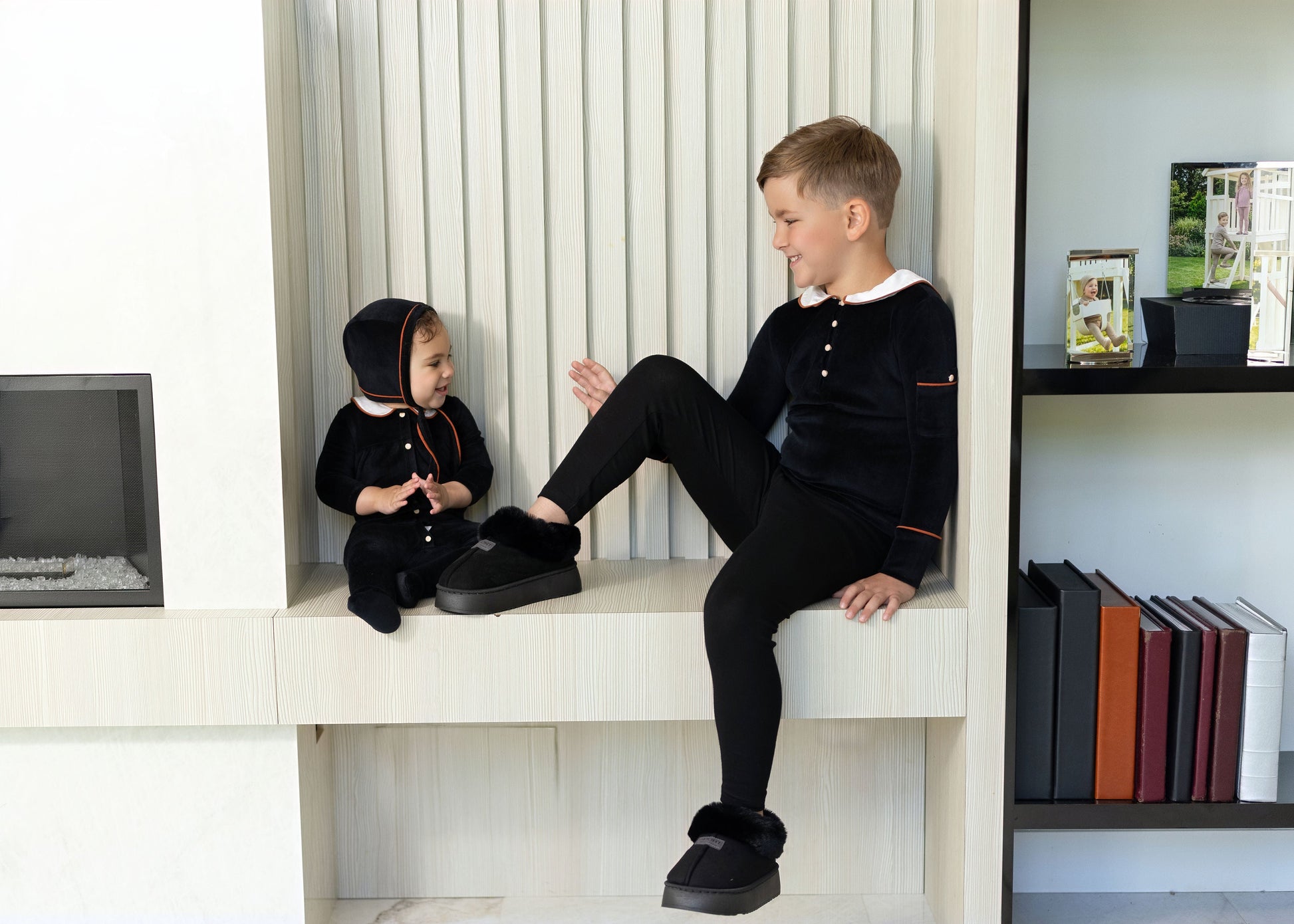 Kids wearing matching Dottie Lou Classic Noir black velour loungewear with ivory Peter Pan collars and orange piping — family photo 5