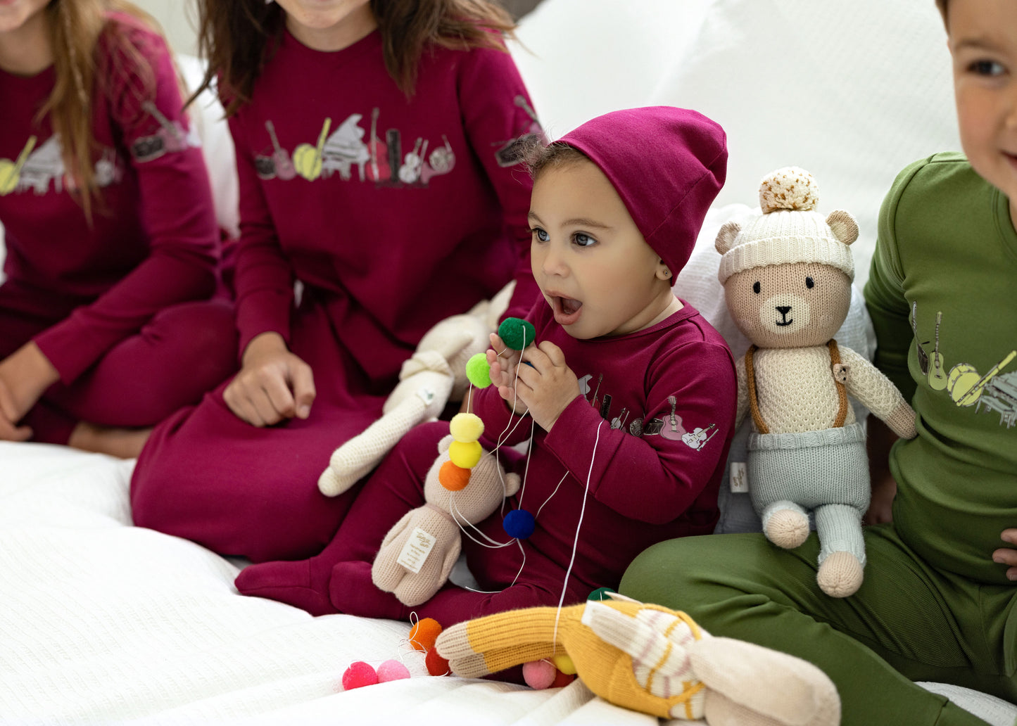 Siblings in matching Dottie Lou Melody berry music-print footie pajamas - lifestyle photo
