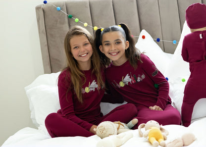 Kids in matching Dottie Lou Melody berry and moss green pajamas with music print — family photo 1